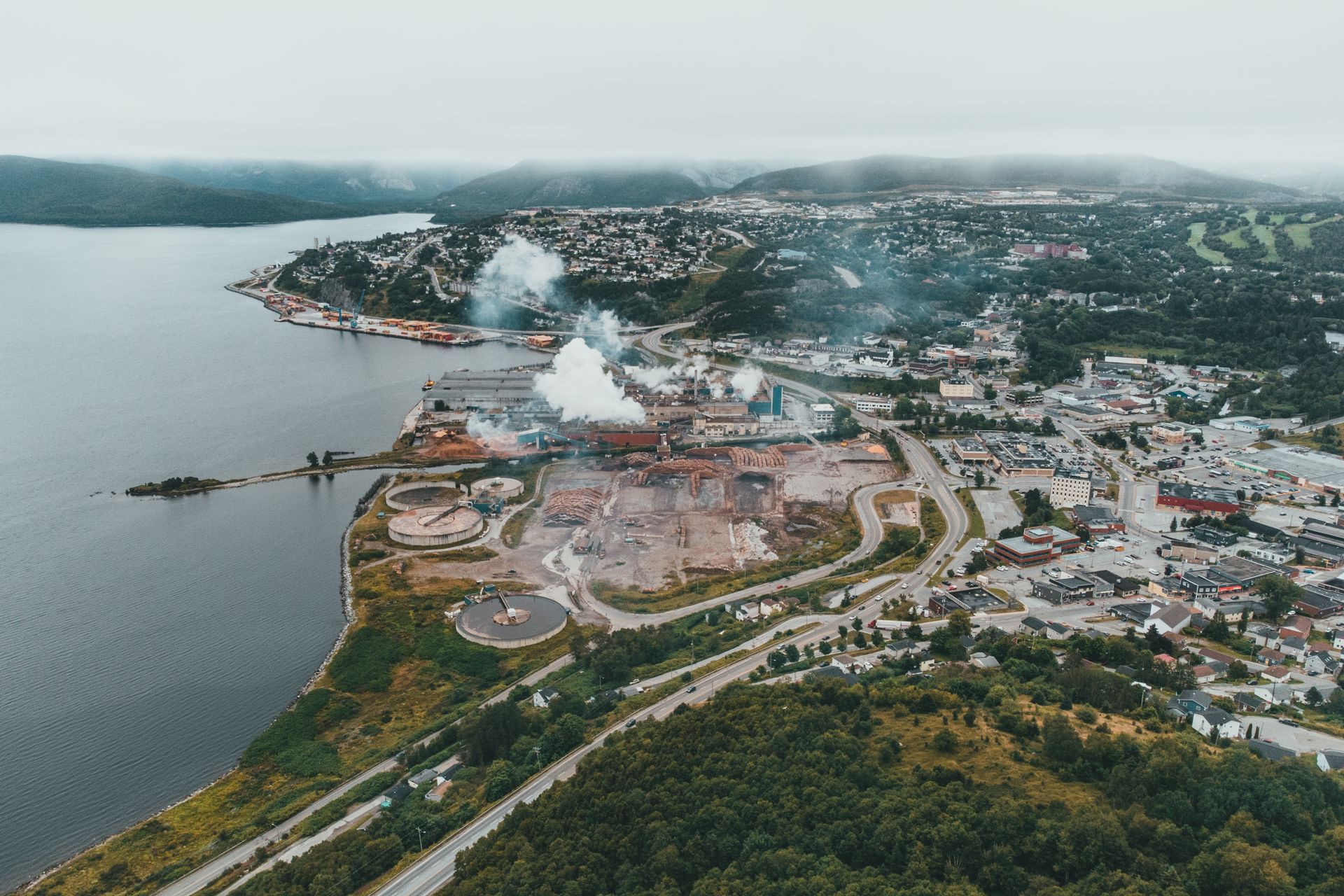 Veduta aerea di una zona industriale costiera con porto, impianti e stabilimenti