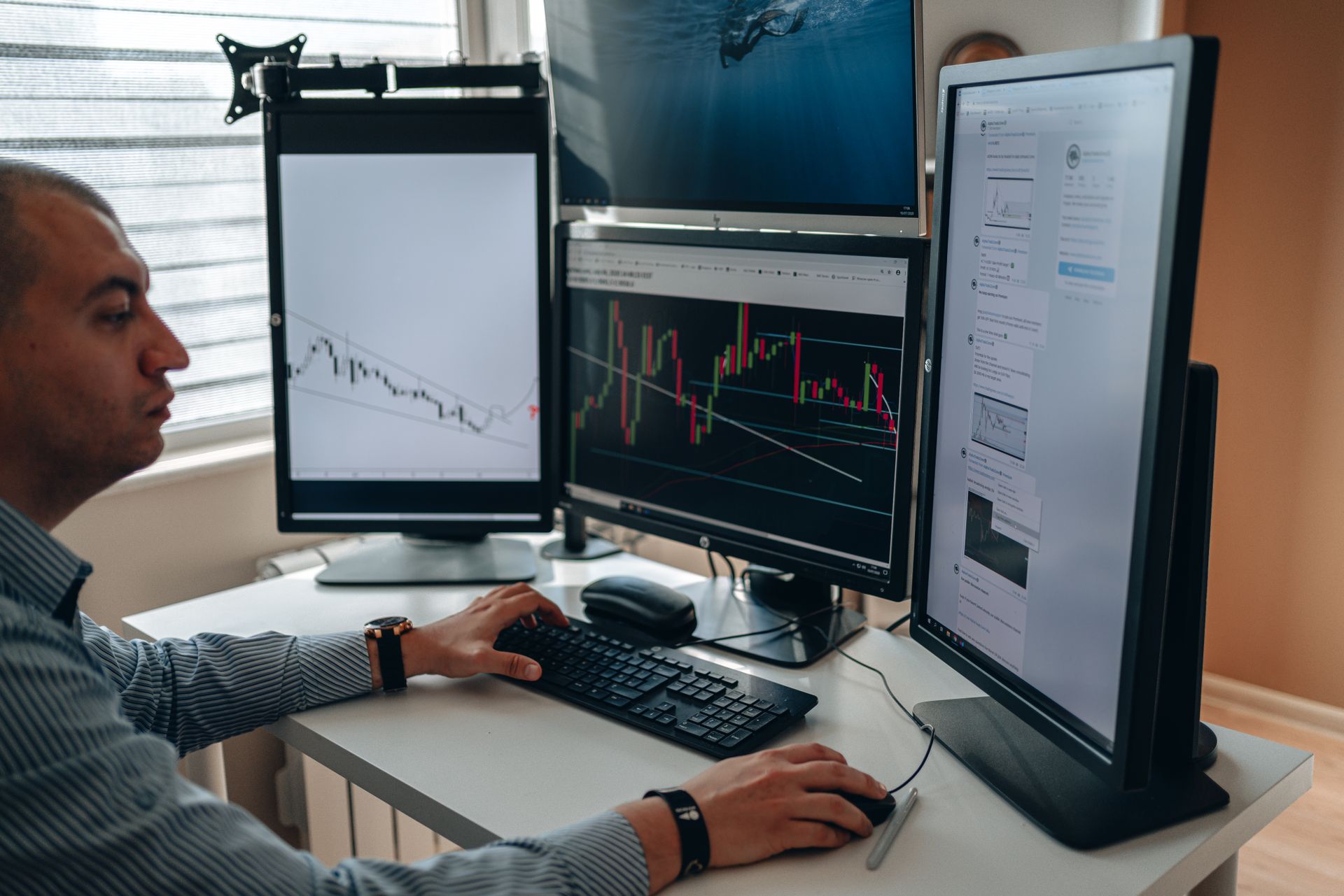 Trader che analizza grafici di mercato su più schermi